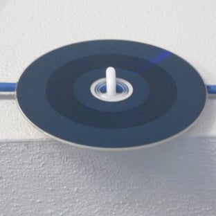 A cd on a white surface
AI-generated content may be incorrect.