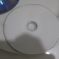 A white cd on a white surface
AI-generated content may be incorrect.