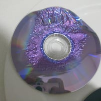 A broken cd on a white surface
AI-generated content may be incorrect.