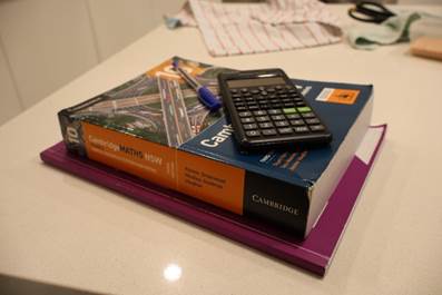 A calculator and a book on a table
AI-generated content may be incorrect.